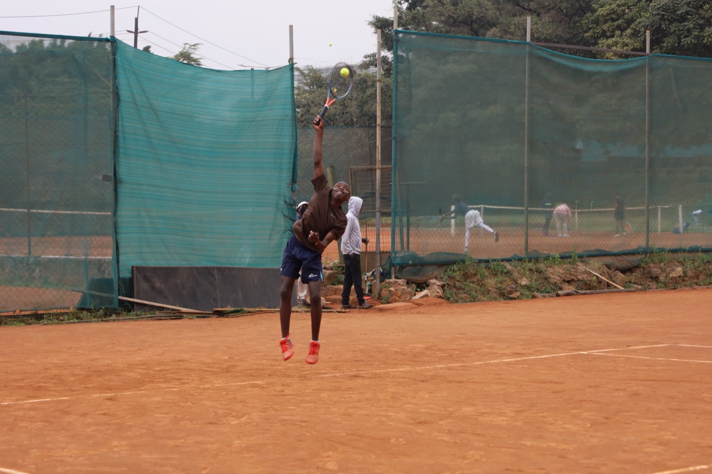 Young player leaping into a serve
