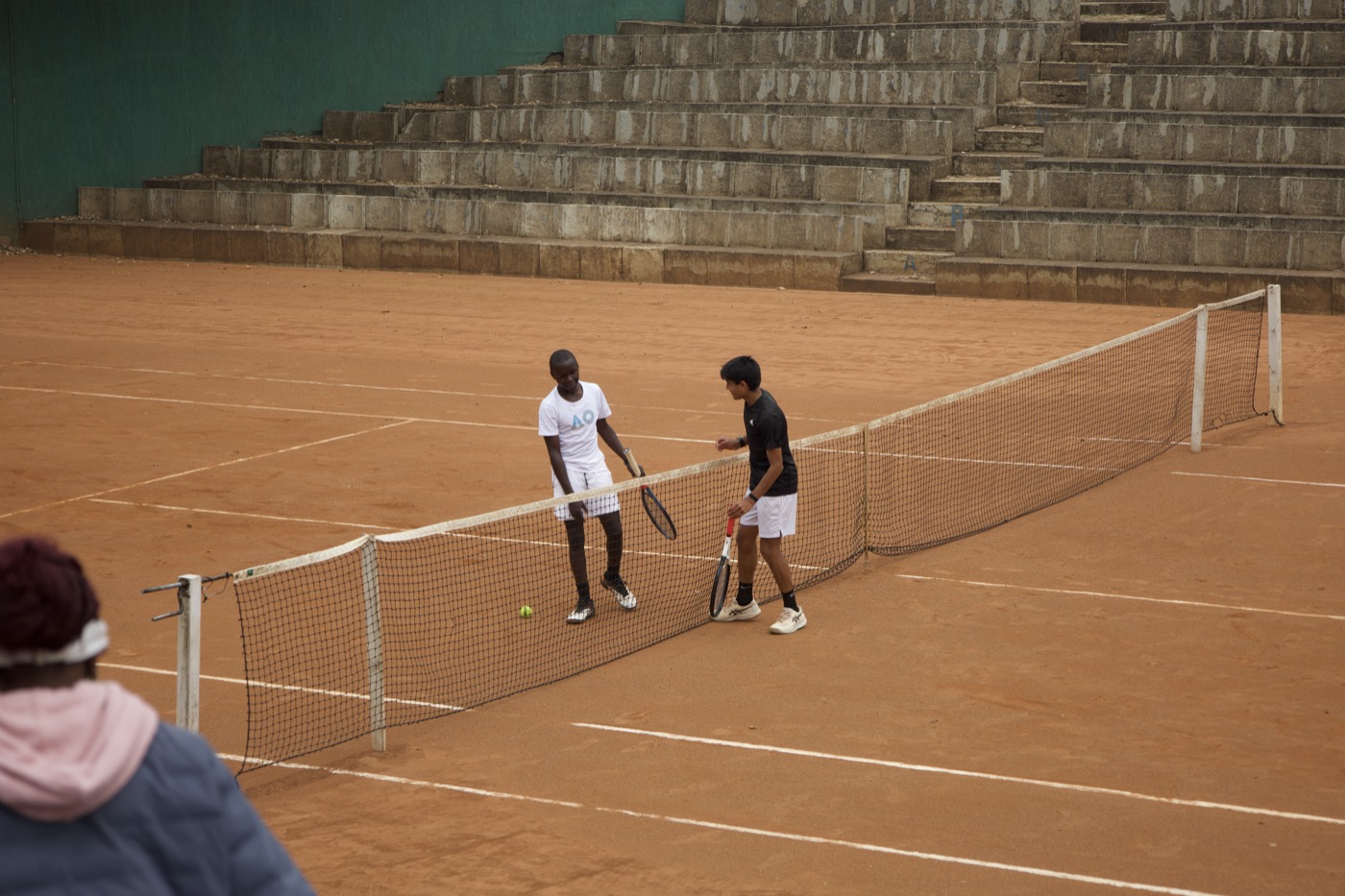 Two players shaking hands at the net after a match