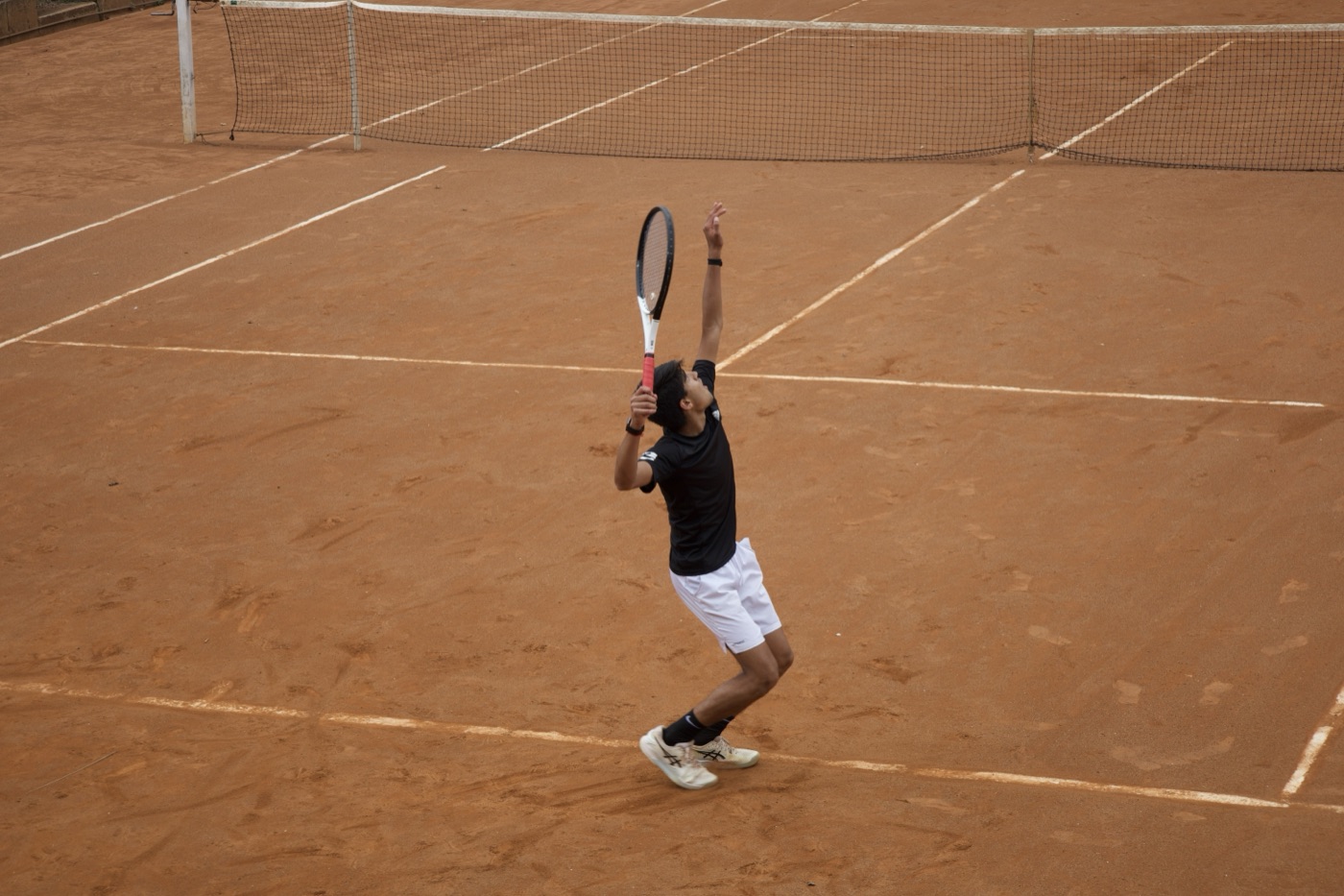 Player mid-serve with textbook form