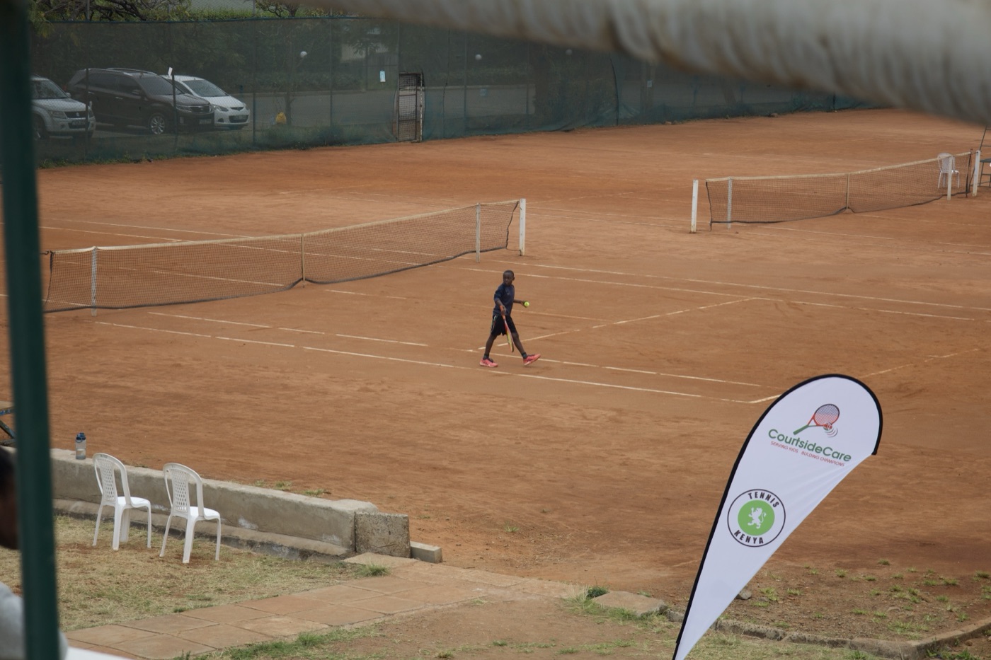 Court with the Courtside Care banner flag, player mid-match