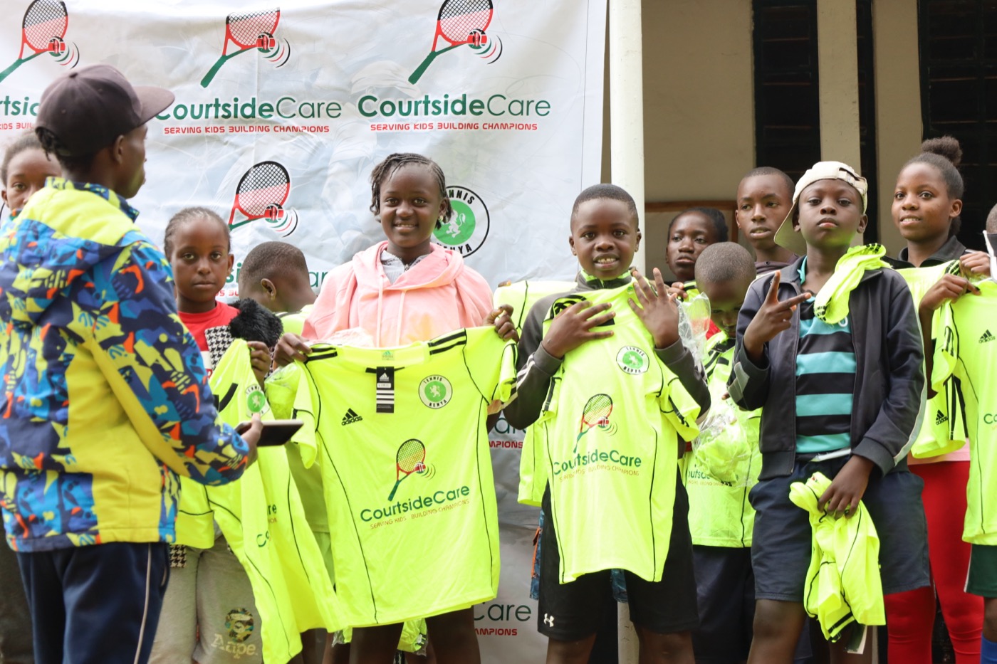 Young athletes holding up their Courtside Care team jerseys