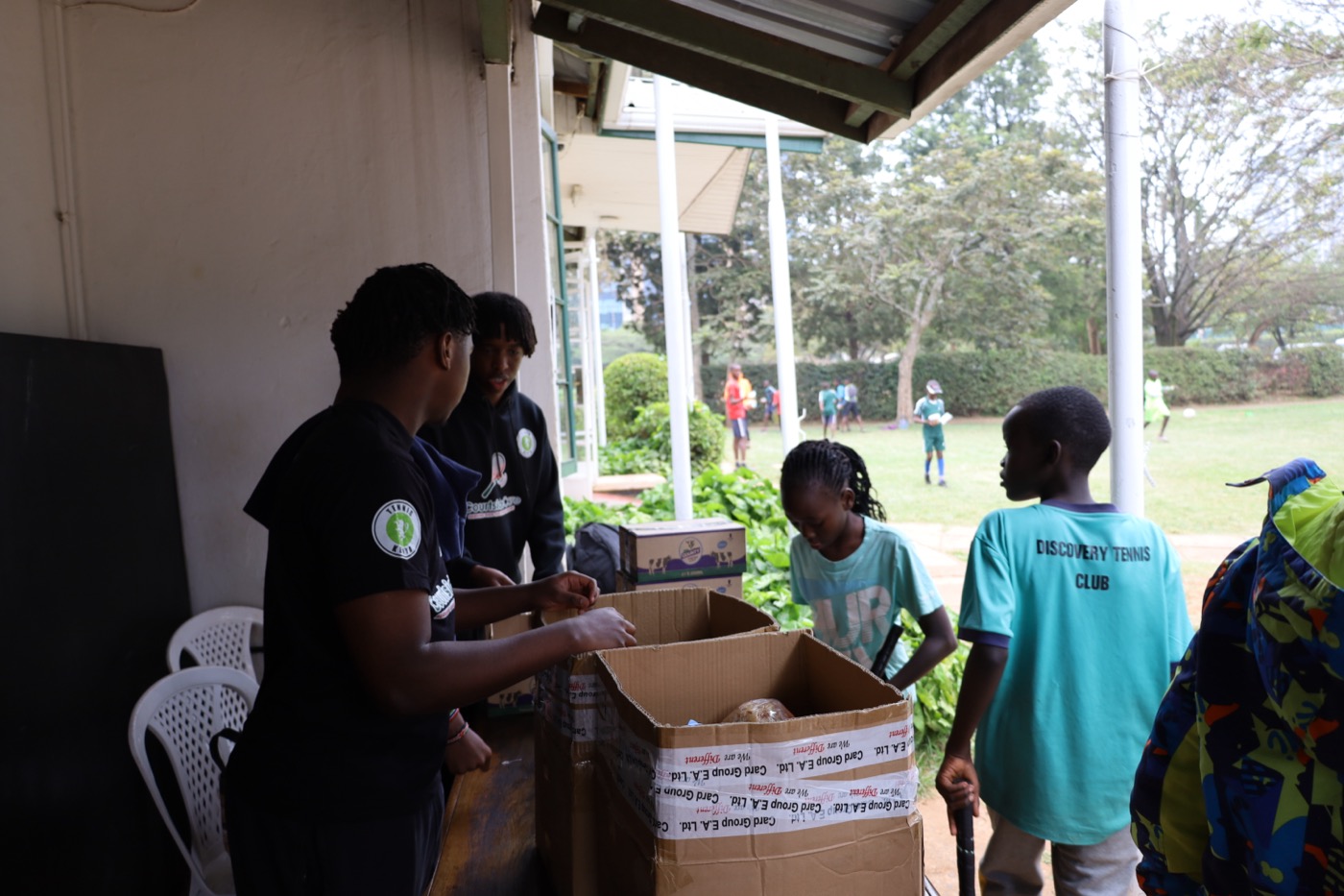 Coach handing out supplies to young athletes and their families