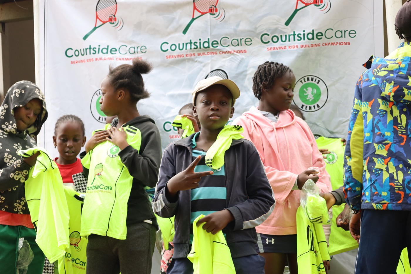 Young athletes holding up their Courtside Care team jerseys